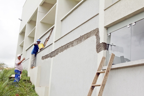 ESTAMOS EM OBRA - Pedreiros fazem reparos em parede externa ao lado do estacionamento dos vereadores. Do lado interno, laudo constatou rachaduras e infiltrações em diversas salas da Câmara